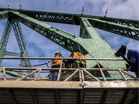 A crew works on installing lighting on the Jacques Cartier Bridge in Montreal, on Monday, December 19, 2016. The $39.5-million bridge-lighting project, the most expensive of its kind in the world, is part of the city's 375th anniversary celebrations.