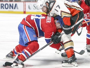 Montreal Canadiens Brendan Gallagher buries his head in Anaheim Ducks Ryan Kessler's midsection while battling for the puck during third period of National Hockey League game in Montreal Tuesday Dec. 20, 2016.