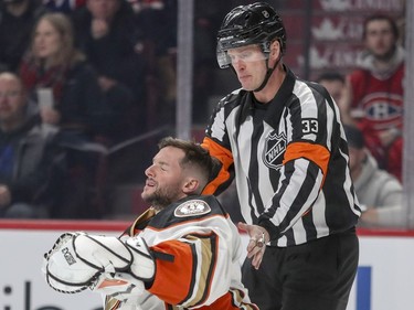 Referee Kevin Pollock checks on Anaheim Ducks goalie Jonathan Bernier after he was involved in a collision with Montreal Canadiens Brendan Gallagher during first period of National Hockey League game in Montreal Tuesday Dec. 20, 2016.