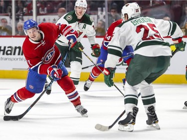 Montreal Canadiens Brendan Gallagher shoots the puck as Minnesota Wild Jonas Broidin tries to get in the way, as Wild's Eric Staal trails during third  period of National Hockey League game in Montreal Thursday Dec., 2016.
