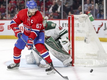 Montreal Canadiens Max Pacioretty has the puck skip over his stick next to Minnesota Wild goalie Devan Dubnyk during first period of National Hockey League game in Montreal Thursday Dec. 22, 2016.