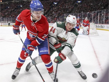 Montreal Canadiens Nathan Beaulieu, left, and  Minnesota Wild's Mikael Granlund battle for the puck near the boards during second period of National Hockey League game in Montreal Thursday Dec. 22, 2016.