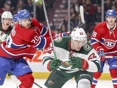 Montreal Canadiens Zach Redmond gets his stick on the back of Minnesota Wild's Nino Niederreiter during second period of National Hockey League game in Montreal Thursday Dec. 22, 2016.