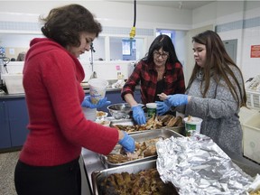 Emmanuelle Tassé left,  Michele Badrutt, middle, and Roxane Gallant prepare turkey dinners to be sent out to families in the neighbourhood of Hochelaga Maisonneuve after a afternoon dinner at CAP Saint-Barnabe in Montreal on Sunday, Dec. 25, 2016.