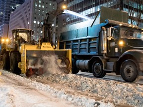 Crews clear Robert-Bourassa Blvd. as the city begins snow- clearing operations in Montreal on Friday Dec. 30, 2016.