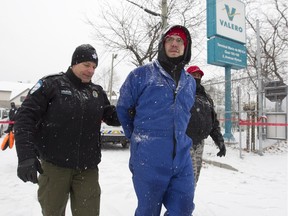 Montreal police officers arrest a Greenpeace activist who chained himself to equipment of the Valero loading zone at the Port of Montreal Dec. 5, 2016.