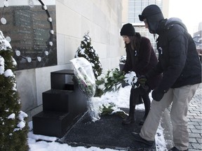 Clara Levy-Provençal and Joël Girard-Lauzièrehe lay flowers at the base of the plaque commemorating the 14 women killed at École Polytechnique Dec. 6, 2016, the 27th anniversary of the massacre.