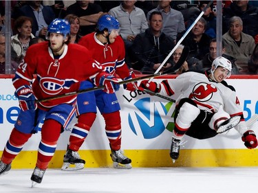 New Jersey Devils left wing Miles Wood grimaces as he is knocked to the ice by Montreal Canadiens defenceman Zach Redmond during NHL action at the Bell Centre in Montreal on Thursday December 8, 2016. Montreal Canadiens left wing Phillip Danault, left, is also seen.