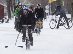 Jonathan Theoret uses a shovel in front of his bike to clear a path to other cyclists as he participates in a shovel-in protest on the Lachine Canal Dec. 9, 2016, to promote awareness to the lack of snow-clearing at the Lachine Canal bike path.