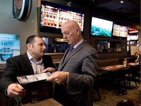 Peter Sergakis, right, owns and operates the Montreal sports bars, Station des Sports. Sergakis discusses a possible menu change with the Sainte-Catherine street location manager, Nathan Rashcovsky, in Montreal on Friday December 9, 2016.