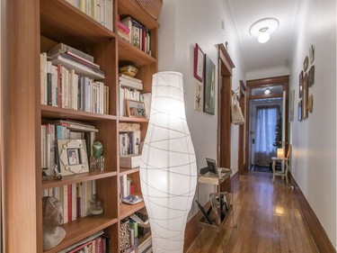 A view of the long hallway with artwork and bookshelves at the apartment of Marie-Thérèse Nichele in Plateau-Mont-Royal.