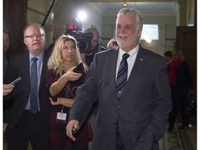 Quebec Premier Philippe Couillard smiles as he walks away from a party caucus meeting, Friday, December 9, 2016 at the legislature in Quebec City. The Fall session is coming to an end. National Assembly sittings will resume in February.