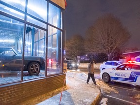 A police car sits outside a used car dealership in east end Montreal after it was hit by arsonists early Wednesday morning.