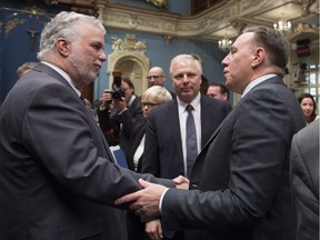 Quebec Premier Philippe Couillard, left, shakes hand with Coalition Avenir Quebec leader Francois Legault as Parti Quebecois leader Jean-Francois Lisée, centre, looks on.