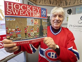 Author Roch Carrier holds up a copy of his iconic Canadian children's book The Hockey Sweater in Owen Sound, Ont., on Dec. 7, 2016.