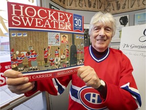 Author Roch Carrier holds up a copy of his iconic Canadian children's book "The Hockey Sweater" at the Georgian Bay Symphony office on Wednesday, Dec. 7, 2016, in Owen Sound, Ont.