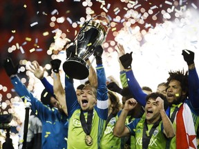 Seattle Sounders midfielder Osvaldo Alonso (6) hoists the MLS Cup with teammates after defeating Toronto FC during shootout MLS Cup soccer final action in Toronto on Saturday, Dec. 10, 2016.