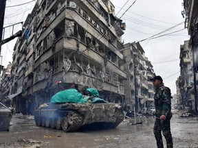 Syrian pro-government forces advance in the Jisr al-Haj neighbourhood during the ongoing military operation to retake remaining rebel-held areas in the northern embattled city of Aleppo on December 14, 2016.  Shelling and air strikes sent terrified residents running through the streets of Aleppo as a deal to evacuate rebel districts of the city was in danger of falling apart.