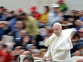 Pope Francis waves to the crowd of faithful as he arrives for his weekly general audience in St Peter's Square at the Vatican on April 27, 2016.