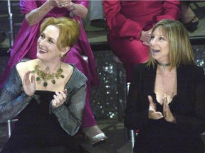 In this March 23, 2003, file photo, Meryl Streep, left, and Barbra Streisand applaud on stage during a reunion of past Oscar winners during the 75th Academy Awards in Los Angeles. Streisand told MSNBC Hardball host Chris Matthews on Monday that she completely agrees with Streep's criticisms of Trump during the Golden Globes on Sunday, Jan. 8, 2017.