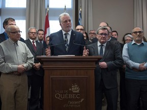 Quebec Premier Philippe Couillard (center podium), Régis Labeaume, Quebec city mayor (second right) during a press conference Jan. 30, 2017, in Quebec city with other officials and representatives of the Muslim community