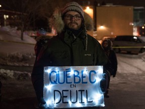 A man holds a sign "Quebec mourning" during a rally near the Islamic Cultural Center in Quebec City, Canada on January 30, 2017. Gunmen stormed into a Quebec mosque during evening prayers January 29 and opened fire on dozens of worshippers, killing six and wounding eight in what Canadian Prime Minister Justin Trudeau condemned as a "terrorist attack." Canadian police sought Monday to piece together the motive for a shooting attack, one of the worst attacks ever to target Muslims in a western country. /