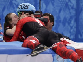 Charles Hamelin embraces Marianne St-Gelais after he won the men's 1,500m short track speedskating final at the Iceberg Skating Palace during the 2014 Winter Olympics, Monday, Feb. 10, 2014, in Sochi, Russia.