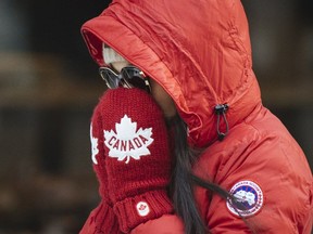 A woman shields her face from the cold during a winter day in Montreal in 2016.