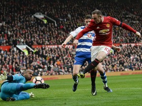 Manchester United's English striker Wayne Rooney, right, has a shat saved by Reading's Omani goalkeeper Ali Al-Habsi during the English FA Cup third round football match between Manchester United and Reading at Old Trafford in Manchester, England, on Jan. 7, 2017.