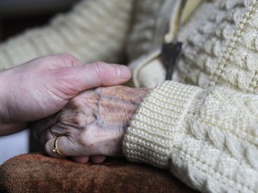 TO GO WITH AFP STORY BY ELISABETH ZINGG (FILES) A picture taken on March 18, 2011 shows a woman suffering from Alzheimer's disease holding the hand of a relative in a retirement house