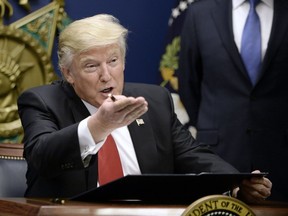 U.S. President Donald Trump signs executive orders in the Hall of Heroes at the Department of Defense on January 27, 2017 in Arlington, Virginia.