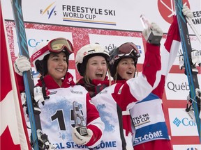 Justine Dufour-Lapointe, centre, of Montreal, celebrates her victory at the women's freestyle moguls World Cup, Saturday, Jan. 21, 2017, in Val-St-Come,  Compatriots Andi Naude, left, placed second and Justine's sister, Chloe Dufour-Lapointe, right, placed third.