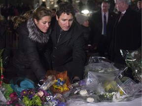 Prime Minister Justin Trudeau and his wife, Sophie Grégoire Trudeau, place flowers at a makeshift memorial during a vigil Monday evening in Quebec City.