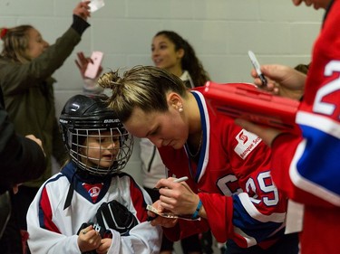 Les Canadiennes forward Marie-Philip Poulin signs an autograph at the Civic Centre in Dollard-des-Oremeaux, Jan. 15, 2017. The Canadian Women's Hockey League game pitted Les Canadiennes against the Calgary Inferno. Les Canadiennes won 4-1. Photo credit: Louis-Charles Dumasi/CWHL