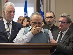 Mohamed Labidi, vice-president of the Islamic cultural centre, is comforted by Quebec Premier Philippe Couillard, left, and Quebec City mayor Regis Labeaume, right, during a news conference about the deadly shooting at a mosque in Quebec City on Monday, January 30, 2017.