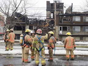 Firefighters survey the scene at an apartment complex fire in Montreal, Friday, December 23, 2016.