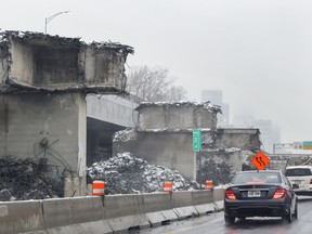 Cars drive on highway 136 next to supports columns that have been left behind during the demolition of the eastbound Ville-Marie expressway in Montreal Wednesday Dec. 7, 2016.