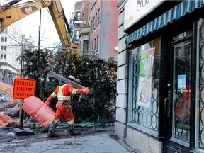 A construction worker carries material past the now-closed Son Ideal shop on Bishop St. in Montreal, Jan. 13, 2017.