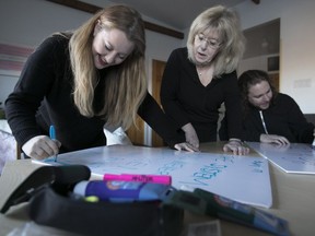 Gillian Sonin, left, and her mother, Helena Sonin, and Daniel Moscovitch make signs on Sunday, Jan. 15, 2017, for the coming rally to coincide with the Women's March on Washington on Saturday, Jan. 21, to support women's rights.