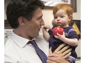 Prime Minister Justin Trudeau tries to get a smile from Annabelle Short while visiting Smoke Meat Pete in Île-Perrot, Jan. 18, 2017.