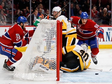 Montreal Canadiens centre Andrew Shaw tries to get to a loose puck as Pittsburgh Penguins right wing Patric Hornqvist holds on to him to stop him from getting to Pittsburgh Penguins goalie Matt Murray during NHL action at the Bell Centre in Montreal on Wednesday January 18, 2017. Montreal Canadiens left wing Phillip Danault looks on from behind the net.
