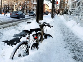 Bikes remain chained to a pole during snow removal hours on rue de Mentana in Montreal on Monday Jan. 2, 2017.