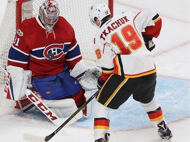 Montreal Canadiens goalie Carey Price stops puck on his chest, while Calgary Flames' Matthew Tkachuk (19) comes in close, during second period NHL action in Montreal on Tuesday January 24, 2017.