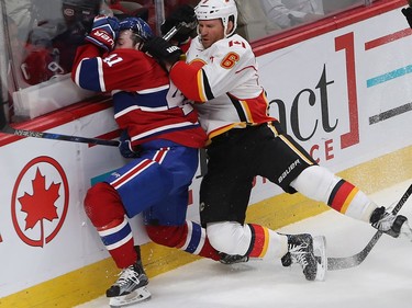 Montreal Canadiens' Paul Byron (41) is put into the boards by Calgary Flames' Dennis Wideman (6) during first period NHL action in Montreal on Tuesday January 24, 2017.