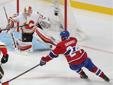 Montreal Canadiens' Phillip Danault (24) keeps eye on puck on rebound by Calgary Flames goalie Chad Johnson during second period NHL action in Montreal on Tuesday January 24, 2017.