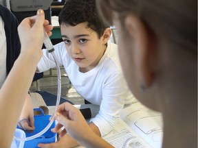 Anthony Perry, 10, watches a tube being filled with water, an experiment called the Hydra, which is part of a hydraulic system workshop. He is helped by (left) Sarah Amaidia and (right) Summer Linhares. Pierre Elliott Trudeau Elementary School is one of two schools at the English Montreal School Board with a STEAM pilot project.