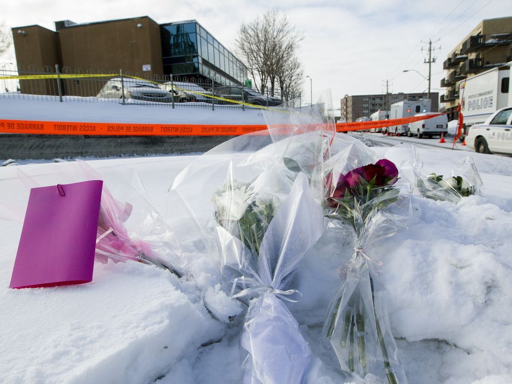 Bouquets lay in the snow near the entrance to the Centre Culturel Islamique de Québec (background) in Quebec City Jan. 30, 2017.