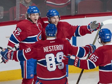 Montreal Canadiens centre David Desharnais, top right, celebrates his goal against the Buffalo Sabres with teammates Sven Andrighetto, top left, Nikita Nesterov, bottom left, and Andrew Shaw, bottom right, during the second period of their NHL hockey match in Montreal on Tuesday, Jan. 31, 2017.