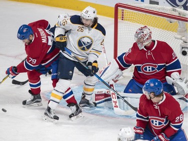 Montreal Canadiens defenceman Andrei Markov, left, battles for the puck with Buffalo Sabres left wing Matt Moulson, centre, as Canadiens goalie Carey Price, right, looks on during the first period of their NHL hockey match in Montreal on Tuesday, Jan. 31, 2017.