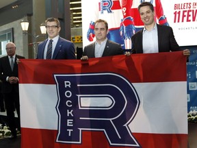 Montreal Canadiens GM Marc Bergevin, from left, team owner Geoff Molson and Vincent Lucier, president of the Place Bell amphitheatre, unveil the logo of the Laval Rocket at a news conference on Tuesday, Jan. 31, 2017 in Laval.